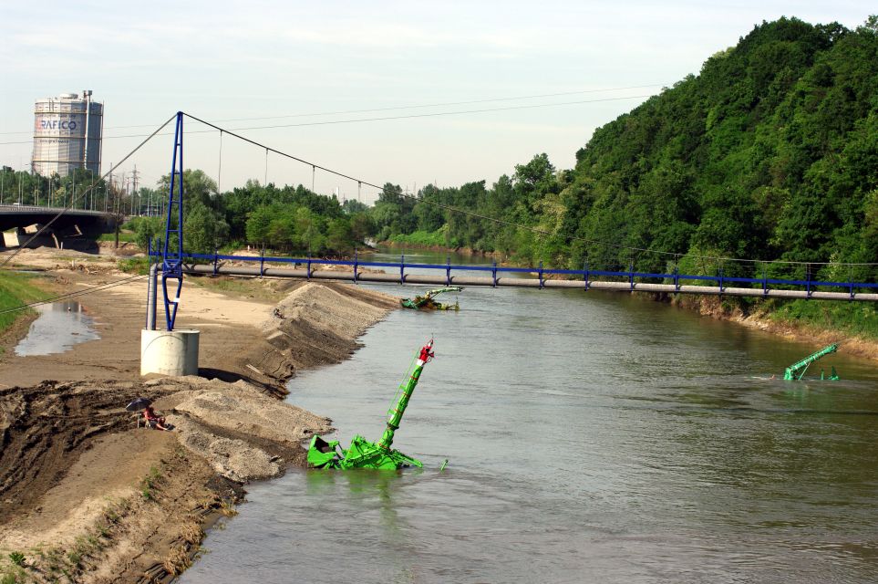 15/28 Řeka Ostravice (most přes ní před plynojemem v levé části snímku) je za povodní stále vydatným zdrojem splavenin. K jejich vytěžení z Odry po povodni v r. 2010 bylo pod soutokem s Ostravicí nutno použít podvodních bagrů Komatsu.